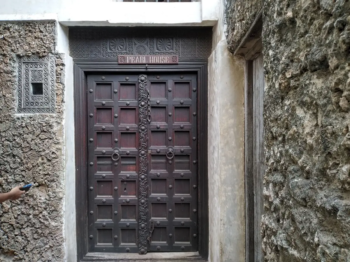 Eine Tür im Lamu-Stil in einer Steinmauer